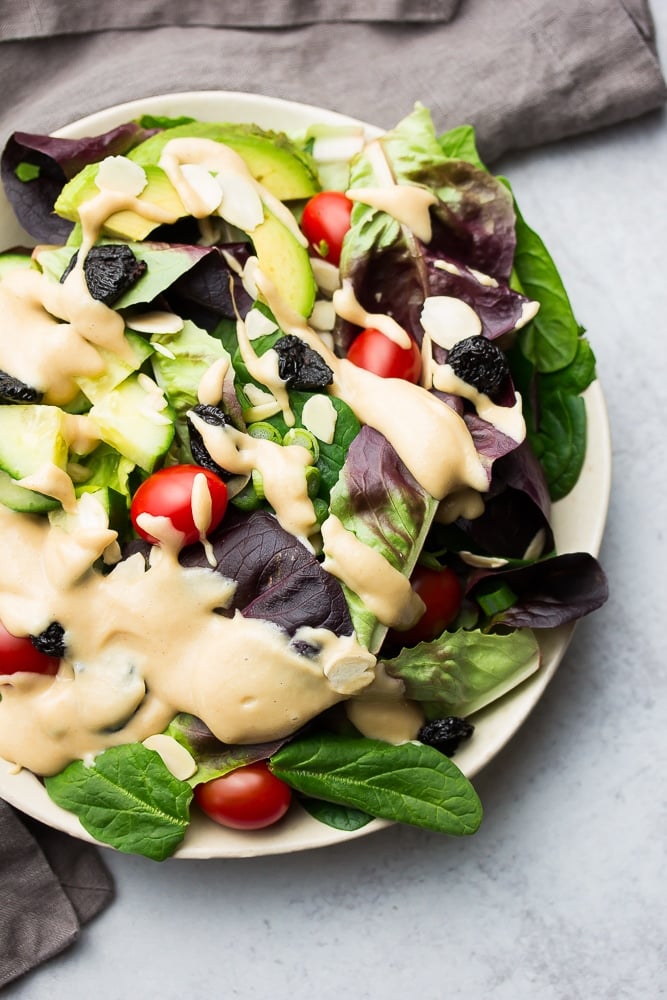 dark leafy greens salad with dressing and tomatoes