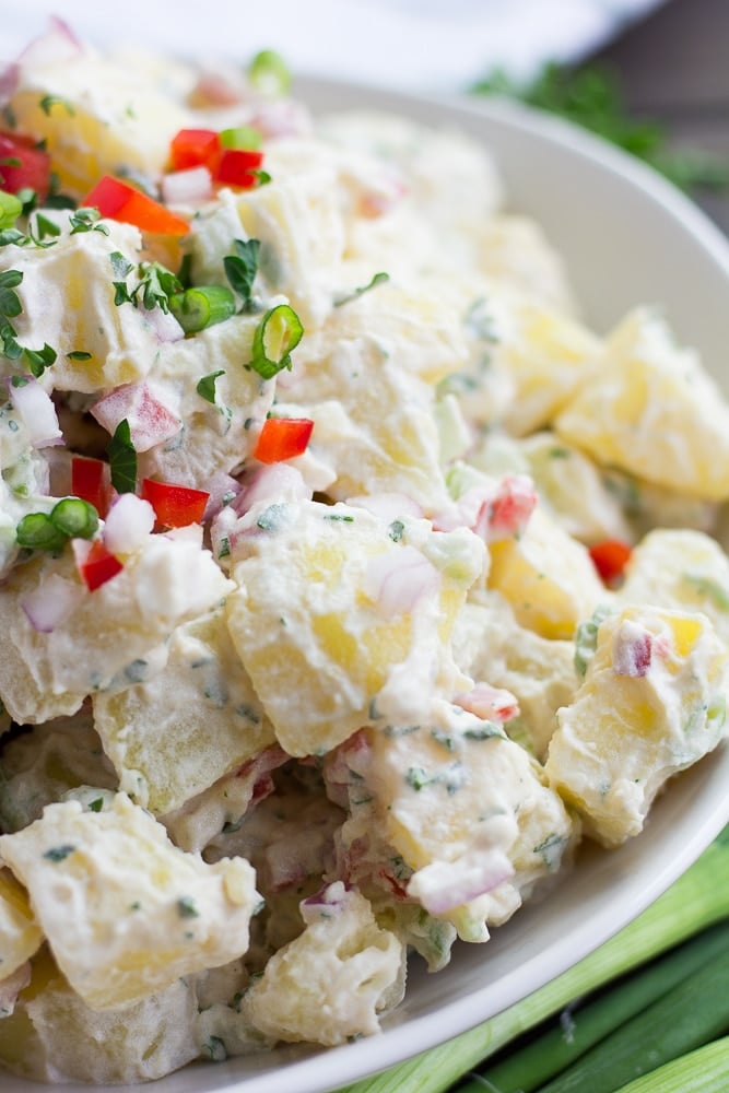 vegan potato salad close up from side in white bowl