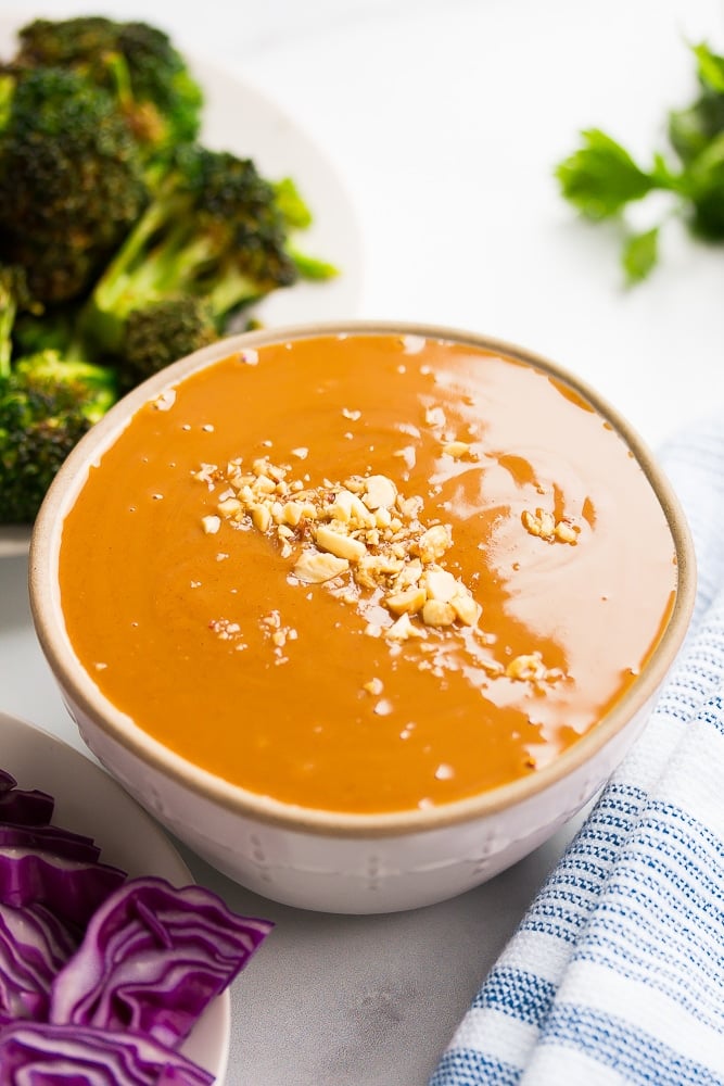 bowl of vegan peanut sauce with crushed peanuts on top