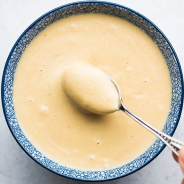 square photo of dressing in bowl with spoon