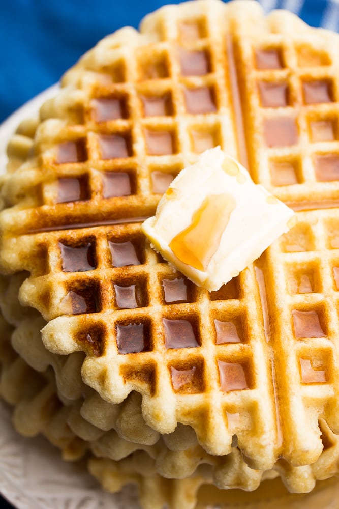 close up of vegan gluten free waffles with blue towel and butter