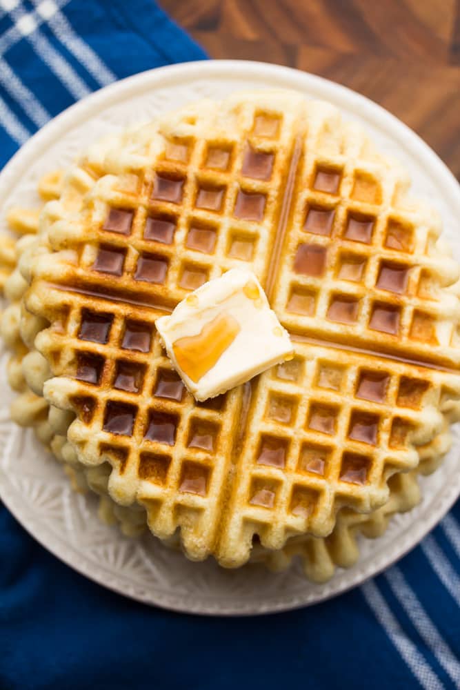 looking down on a plate of waffles with syrup and butter