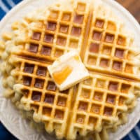 square image of waffles on a plate with butter