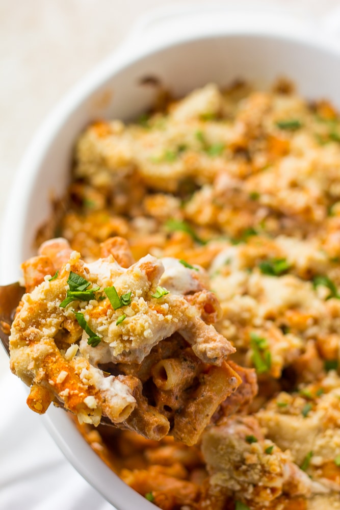 vegan baked ziti on a large spoon out of casserole dish