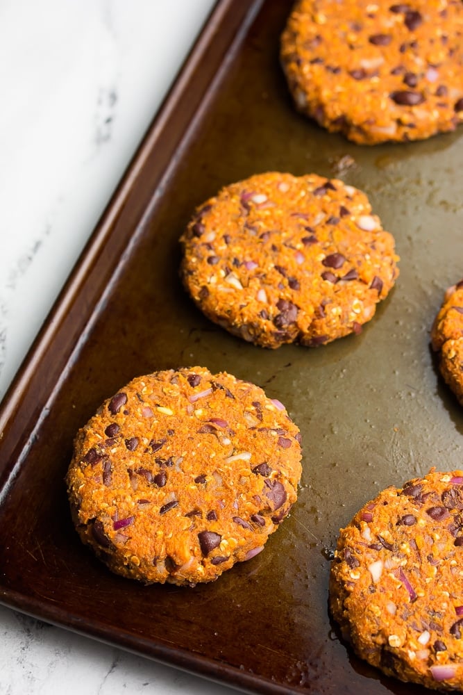 orange and beany burgers, uncooked on a pan