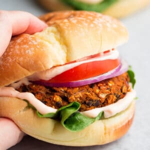 square image of a hand grabbing a burger