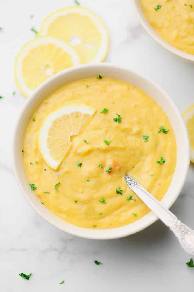 looking down on a bowl of lentil lemon soup, marble backdrop