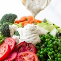 vegan ranch being poured onto a large salad