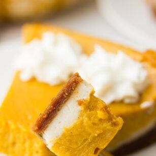 a bite taken of vegan double layered pumpkin cheesecake on a fork