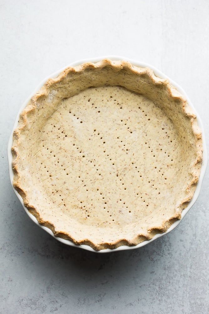 cooked pie crust on a grey background with fork holes