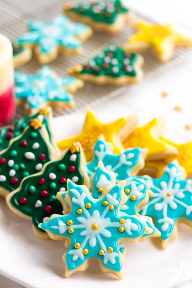 frosted vegan sugar cookies stacked on a plate