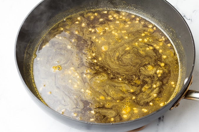 orange tofu sauce in a pan being warmed