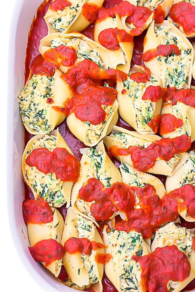 large casserole dish filled with vegan stuffed shells covered in sauce