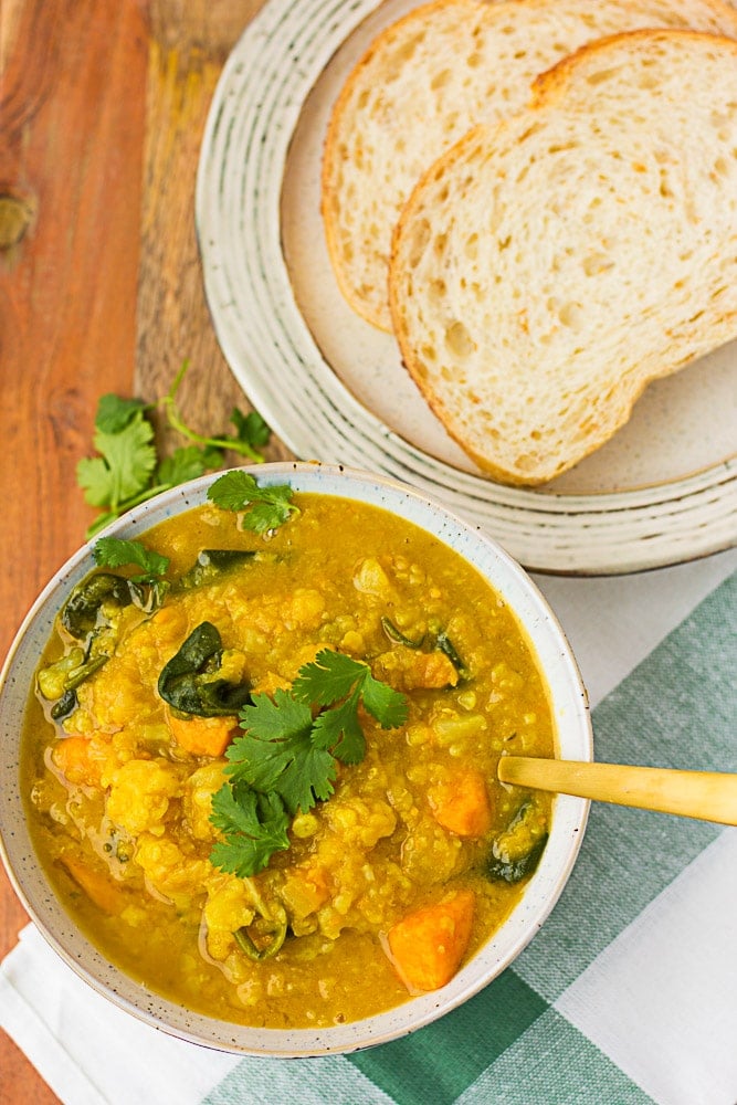 cauliflower sweet potato curry soup with a side of bread.