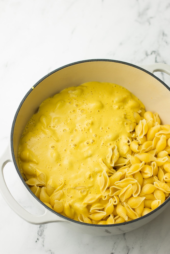 white pot with noodles and cheese sauce poured in, not stirred