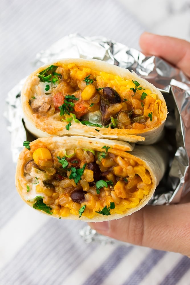 close up of a burrito with colorful filling, wrapped in foil