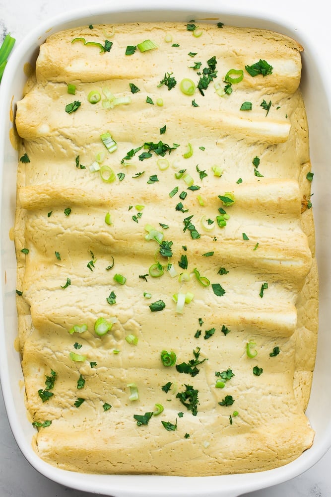 looking down on a pan of sour cream enchiladas with chopped green onion/cilantro