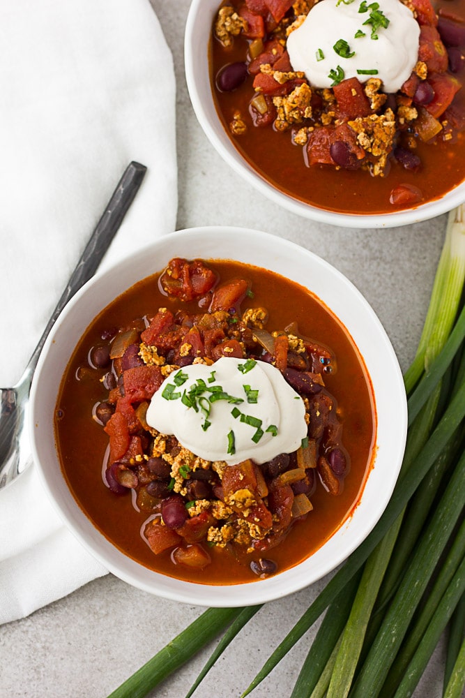 top down photo of 2 bowls of vegan chili with sour cream