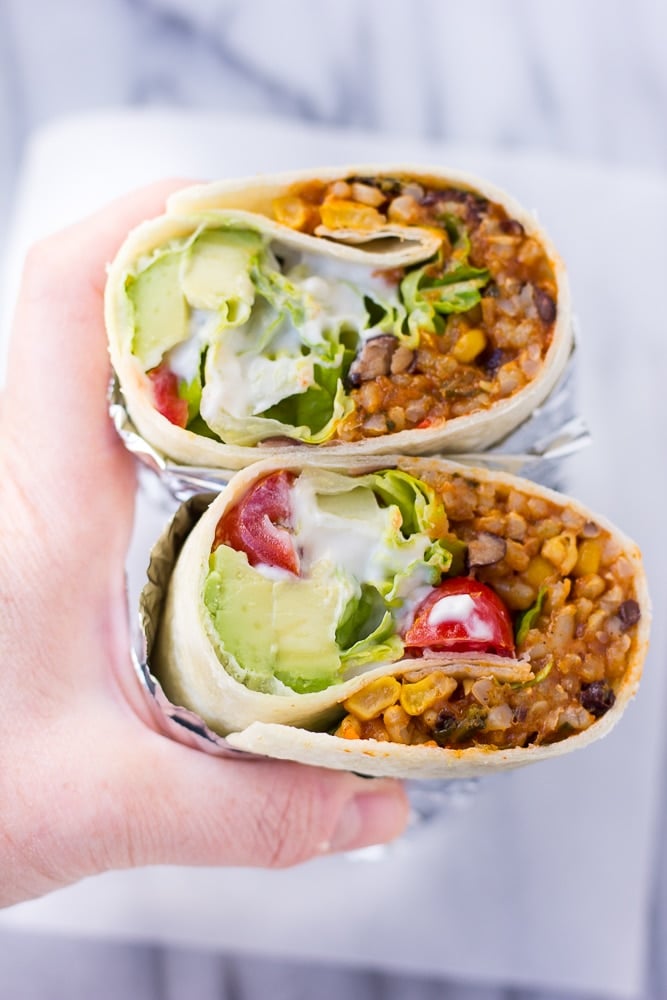 Hand holding instant pot vegan burritos