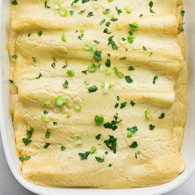 square image of a pan of enchiladas with white sauce