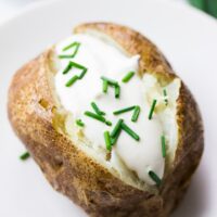 close up of vegan baked potato with vegan sour cream and chives