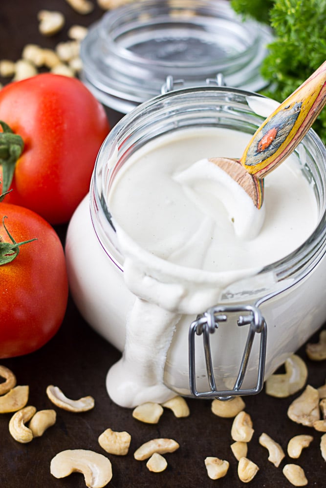 cashew sour cream in a glass dish with tomatoes