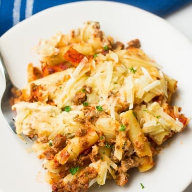 plate with serving of baked ziti on it, blue towel in background