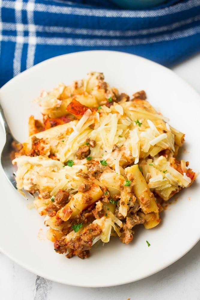 plate with serving of baked ziti on it, blue towel in background