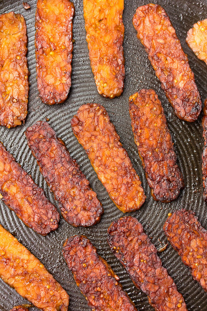 tempeh bacon on a pan being fried