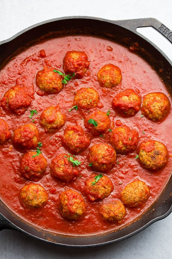 cast iron pan with meatballs in marinara