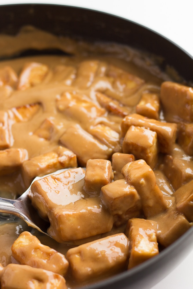 peanut tofu in a pan with a silver spoon