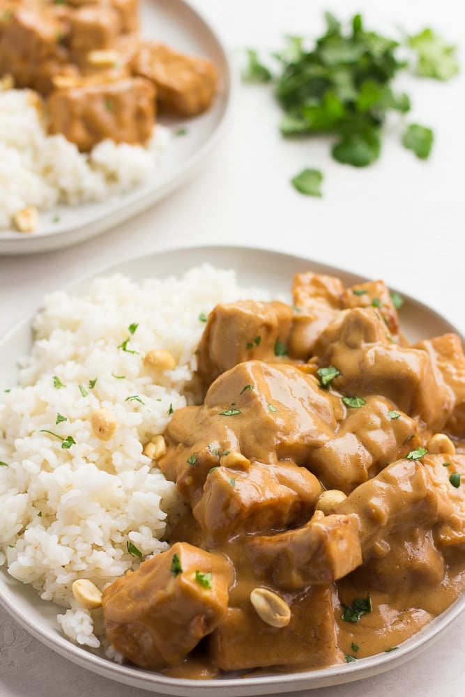 peanut tofu with coconut rice on two plates with cilantro