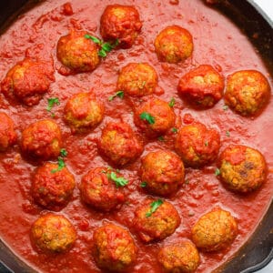 square image of balls in marinara in a cast iron pan