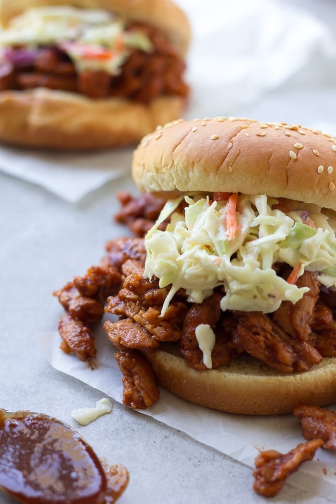 vegan bbq sandwich on parchment paper with coleslaw