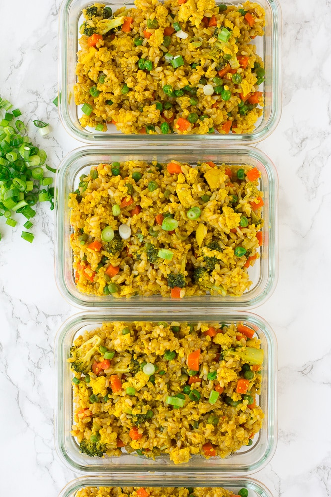 4 glass containers filled with vegan fried rice meal prep dish.