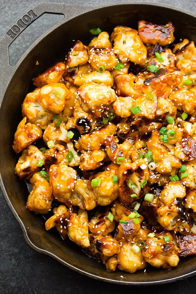 cast iron pan with what looks like cauliflower with a sticky sauce
