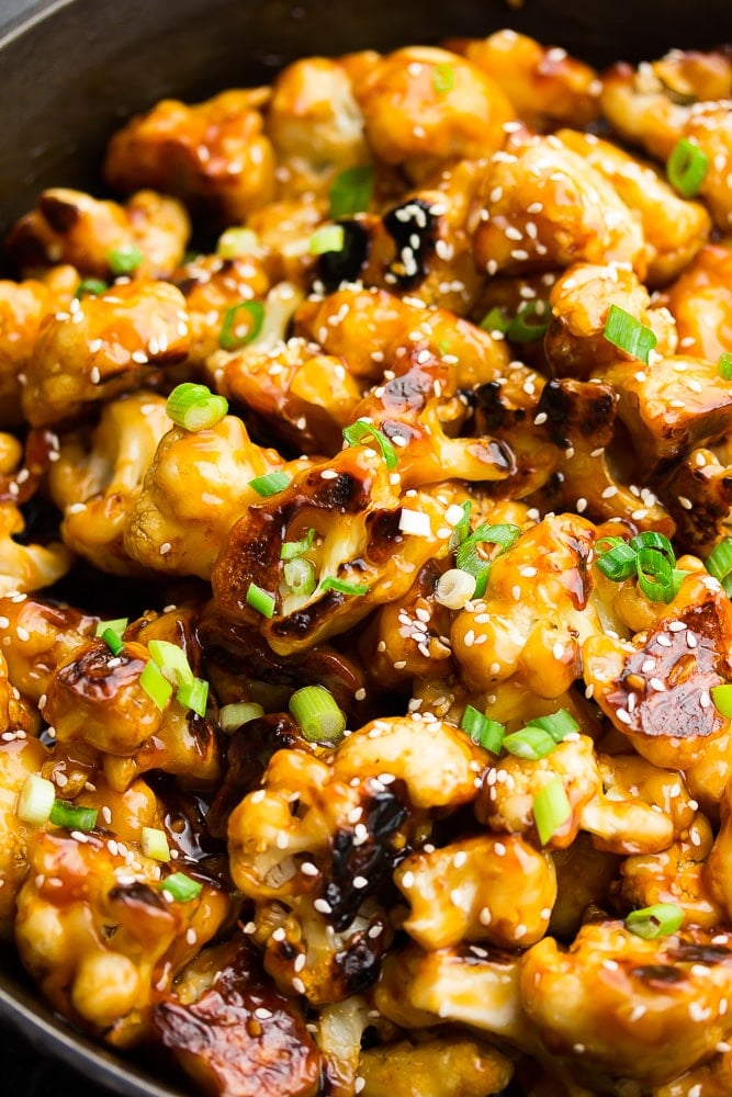 close up of cauliflower in pan with green onions on top