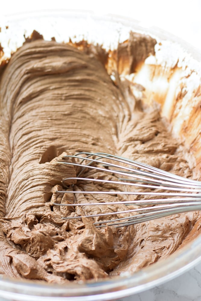 vegan chocolate frosting in a bowl with a whisk