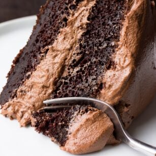 slice of vegan chocolate cake with a fork taking a bite.