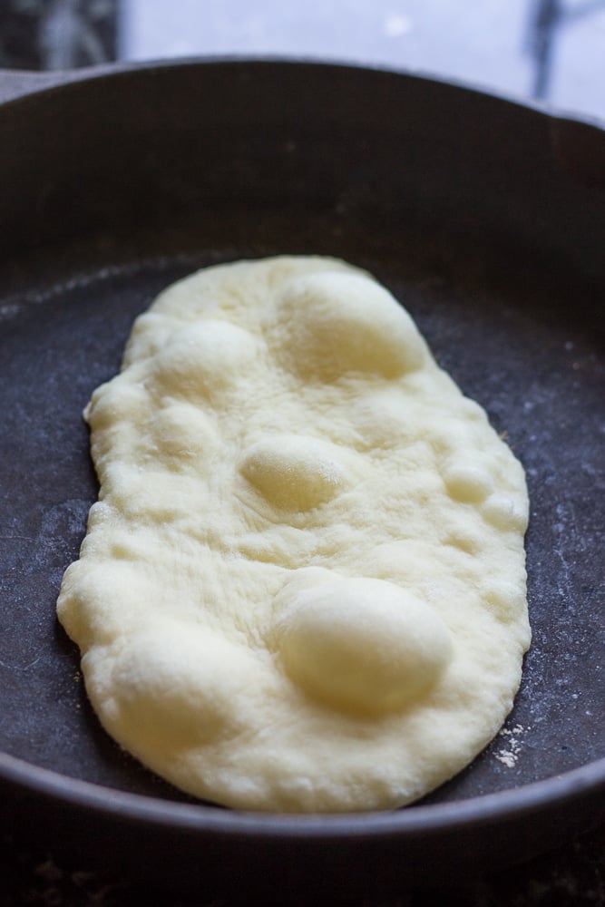 photo of flatbread on pan cooking with bubbles