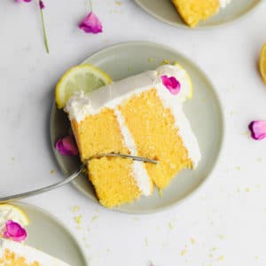 square image of a piece of lemon cake on a plate with a fork in it