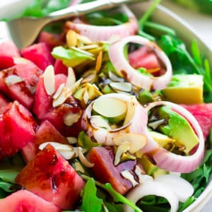 square photo of a salad with avocado and watermelon chunks