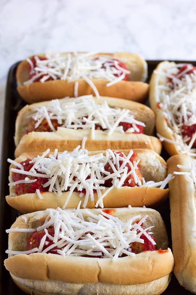 vegan meatballs subs with shredded cheese before baking.