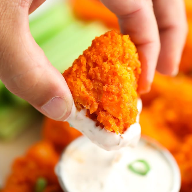 square image of a piece of buffalo cauliflower being dipped into ranch