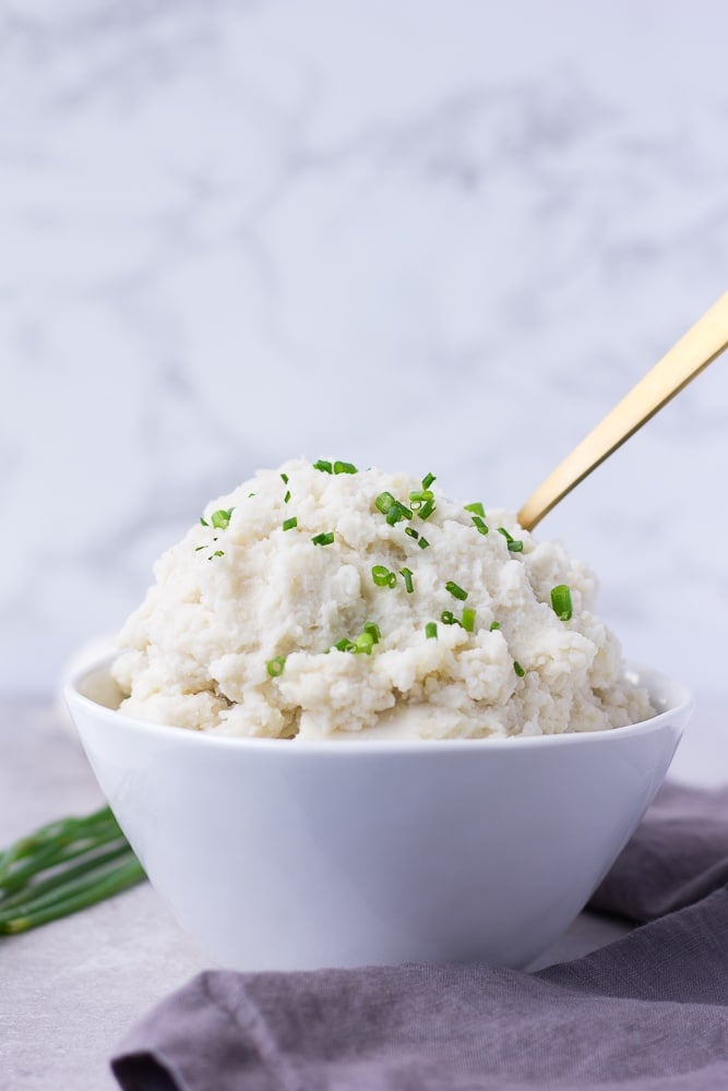 instant pot mashed potatoes from the side in a bowl, gray background