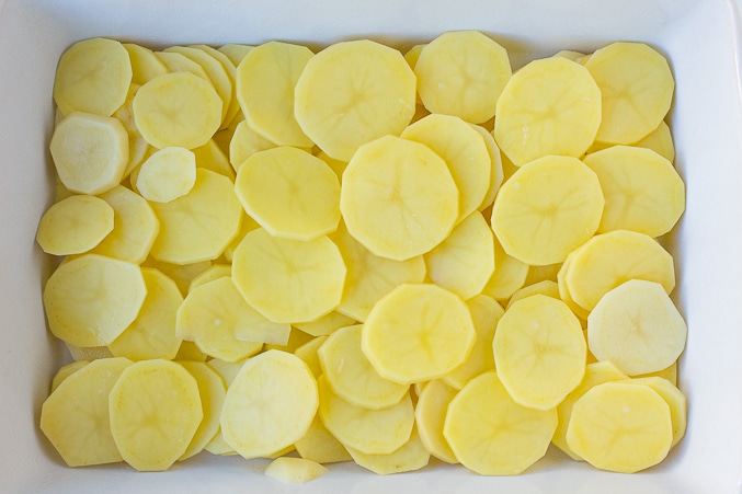 vegan scalloped potatoes, raw potatoes sliced in casserole dish