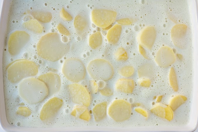 creamy sauce layered over potatoes