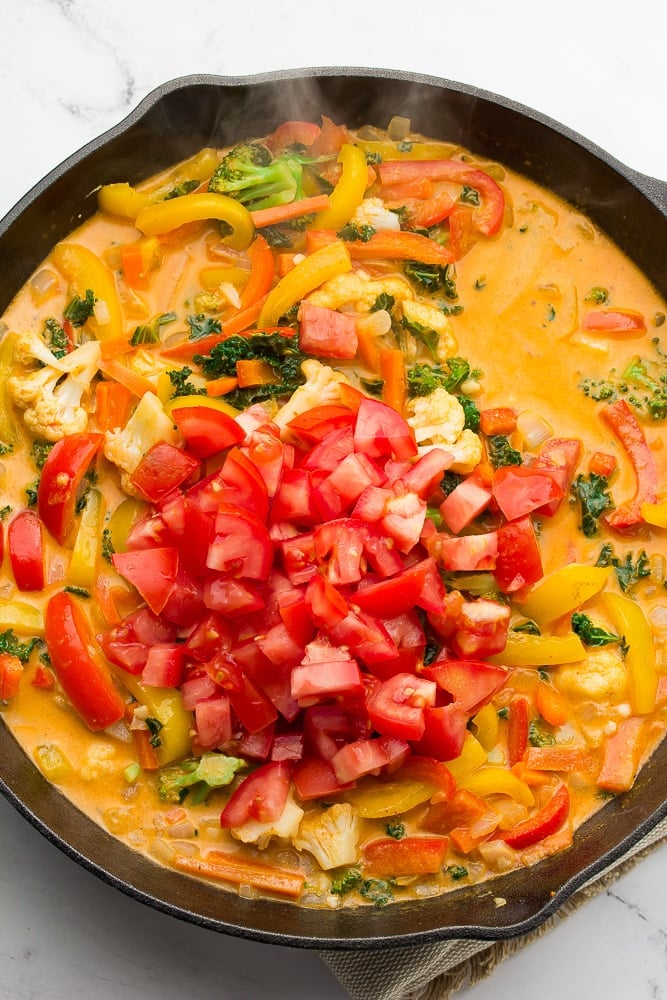 pan with vegetables and tomatoes being added