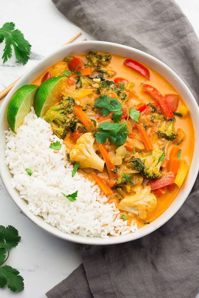 looking down on a bowl with white rice and vegetables in a creamy sauce