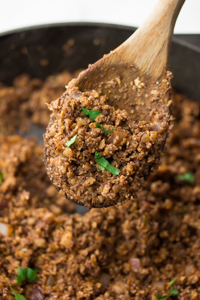 wooden spoon holding taco meat over a pan